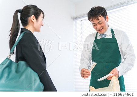 男性便利商店工作人員在收銀台裝袋和女性購物者（筷子和毛巾） 116694601