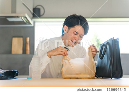 一位穿西裝的亞洲商人回國後在餐廳打開便利商店午餐盒 116694845