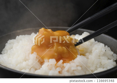 蛋煮飯：用筷子將米夾起，將蛋黃壓碎。 116695348