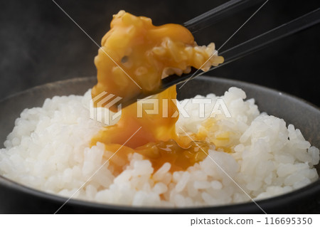 蛋煮飯：用筷子將米夾起，將蛋黃壓碎。 116695350