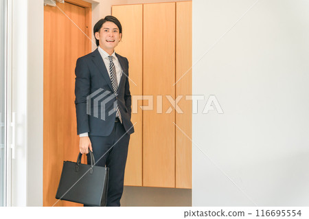 A businessman entering his home from the front door (coming home, home, visiting, sales) A businessman entering his home from the front door (coming home, home, visiting, sales) 116695554