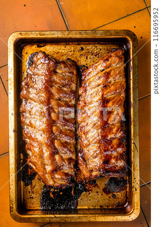 Barbecue grilled pork spare ribs. Orange background. Top view 116695952