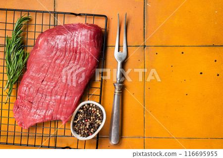 Raw flank beef meat steak ready for grilling. Orange background. Top view. Copy space Raw flank beef meat steak ready for grilling. Orange background. Top view. Copy space 116695955
