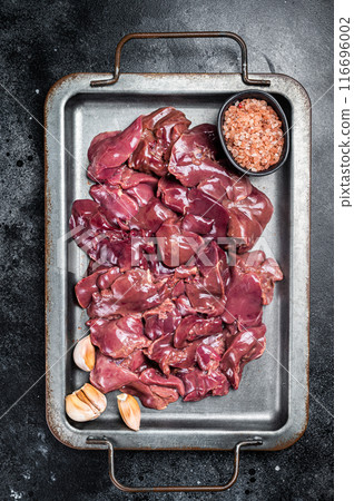 Raw chicken liver meat in steel tray with spices. Black background. Top view 116696002
