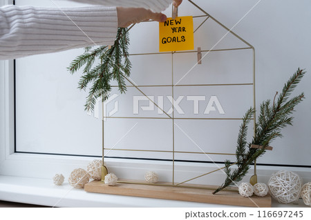 Unrecognizable woman creating action board new year's resolutions on colorful sticky notes. Making promises for new year, setting goals. Dream year Unrecognizable woman creating action board new year's resolutions on colorful sticky notes. Making promises for new year, setting goals. Dream year 116697245