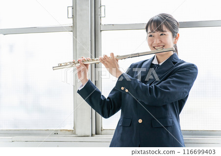 銅管樂隊的亞洲女學生在教室裡吹長笛 銅管樂隊的亞洲女學生在教室裡吹長笛 116699403