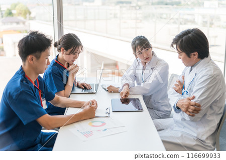 Male and female medical staff holding a conference with serious expressions Male and female medical staff holding a conference with serious expressions 116699933