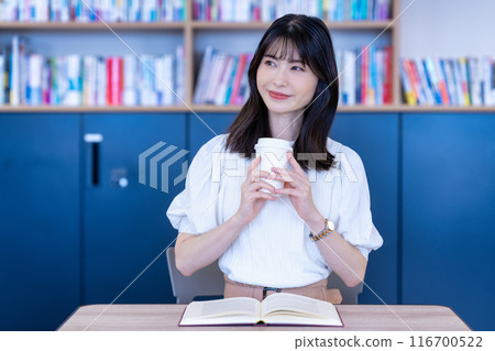 Middle-aged woman reading a book in a cafe 116700522