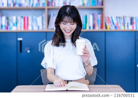 Middle-aged woman reading a book in a cafe 116700531