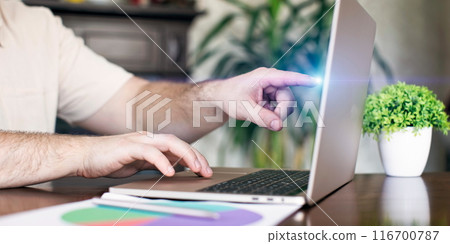 Man working on laptop at home office. Close-up of male hands typing on laptop keyboard. 116700787