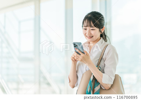在辦公大樓使用智慧型手機的亞洲女商人 116700895