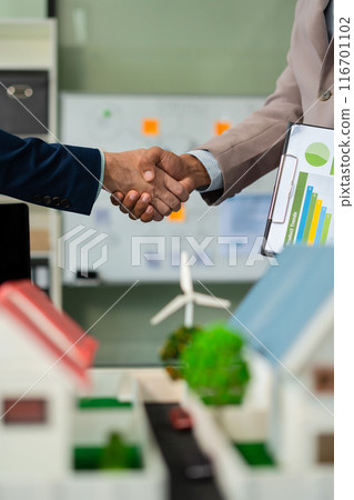 Businessmen shake hands after agreeing to start a new project successfully, renewable and sustainable development, and solar panel concept. 116701102