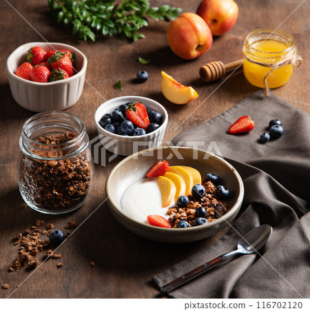 Concept of a healthy and nutritious breakfast. Delicious natural yogurt with homemade granola, peach 116702120