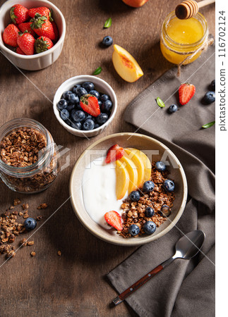 Concept of a healthy and nutritious breakfast. Delicious natural yogurt with homemade granola, peach Concept of a healthy and nutritious breakfast. Delicious natural yogurt with homemade granola, peach 116702124