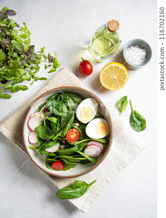 Fresh salad of green spinach leaves, tomatoes, micro greens basil,boiled egg, red radish  116702160