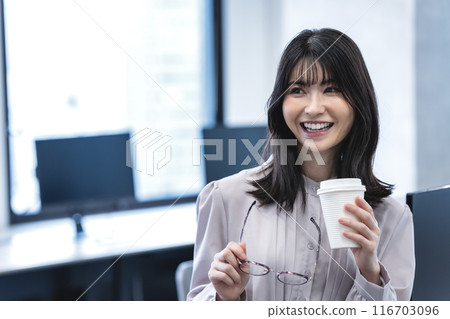 Middle-aged woman having a coffee break in the office Middle-aged woman having a coffee break in the office 116703096
