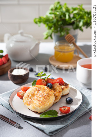 Pancakes with cottage cheese or syrniki with fresh berries, honey and sour cream  116703125