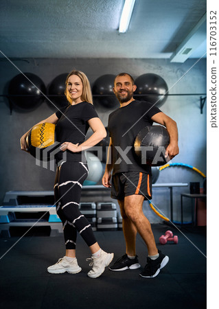 Sporty couple exercising together in gym. Sporty couple exercising together in gym. 116703152