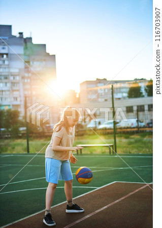 caucasian little basketball player jumps to throw the ball into the basket hoop caucasian little basketball player jumps to throw the ball into the basket hoop 116703907