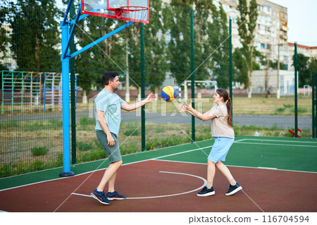 Motion shot of father and kid playing basketball together outdoors 116704594