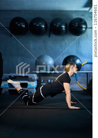 Young attractive sportive woman wearing activewear doing exercises at GYM, 116704601