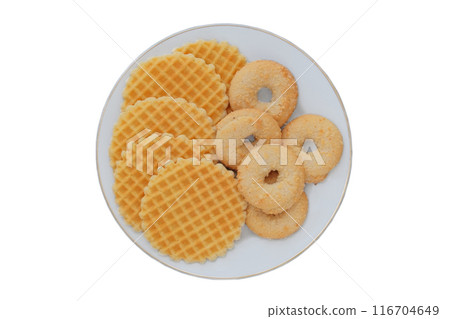Variety of cakes and waffles in ceramic plate isolated on a white background. Yellow romantic biscuit. Top view. Variety of cakes and waffles in ceramic plate isolated on a white background. Yellow romantic biscuit. Top view. 116704649