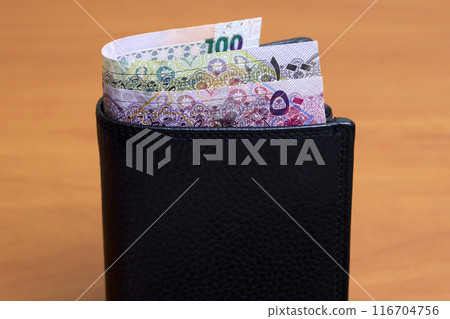 Qatari riyal in the black wallet 116704756