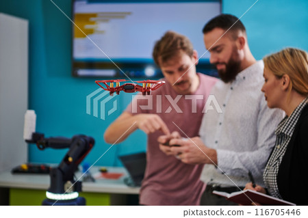 A group of students working together in a laboratory, dedicated to exploring the aerodynamic capabilities of a drone 116705446
