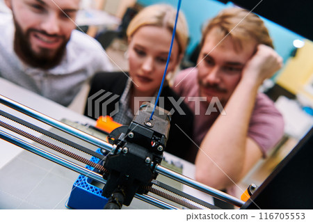 A group of colleagues working together in a robotics laboratory, focusing on the intricate fields of robotics and 3D printing. Showcase their dedication to innovation, as they engage in research 116705553