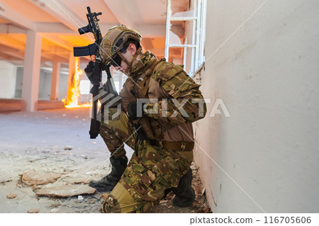 Soldier in action near window changing magazine and take cover 116705606