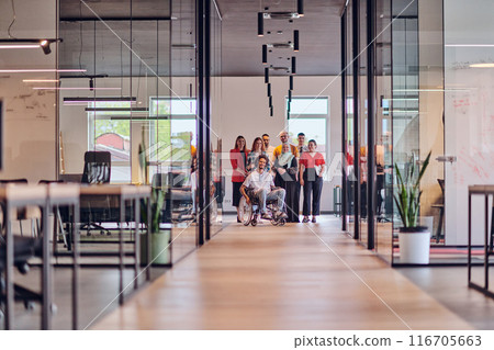 A diverse group of young business people congregates within a modern startup's glass-enclosed office, featuring inclusivity with a person in a wheelchair, an African American young man , and a hijab A diverse group of young business people congregates within a modern startup's glass-enclosed office, featuring inclusivity with a person in a wheelchair, an African American young man , and a hijab 116705663