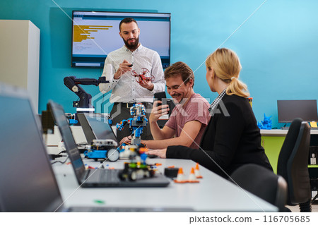 A group of colleagues working together in a robotics laboratory, focusing on the intricate fields of robotics and 3D printing. Showcase their dedication to innovation, as they engage in research 116705685