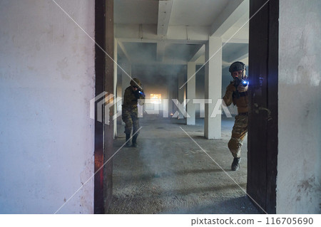 A group of professional soldiers bravely executes a dangerous rescue mission, surrounded by fire in a perilous building. 116705690