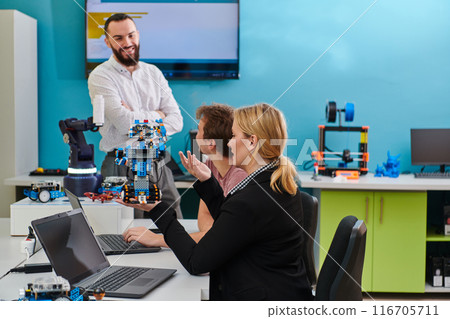 A group of colleagues working together in a robotics laboratory, focusing on the intricate fields of robotics and 3D printing. Showcase their dedication to innovation, as they engage in research 116705711