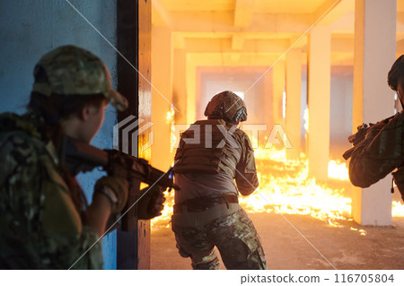 A group of professional soldiers bravely executes a dangerous rescue mission, surrounded by fire in a perilous building. 116705804