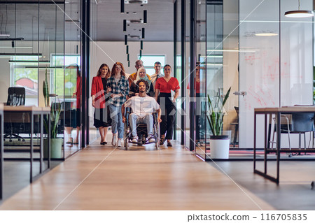 A diverse group of young business people congregates within a modern startup's glass-enclosed office, featuring inclusivity with a person in a wheelchair, an African American young man , and a hijab A diverse group of young business people congregates within a modern startup's glass-enclosed office, featuring inclusivity with a person in a wheelchair, an African American young man , and a hijab 116705835