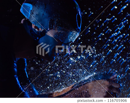 A triathlete braving the rain as he cycles through the night, preparing himself for the upcoming marathon. The blurred raindrops in the foreground and the dark, moody atmosphere in the background add 116705906