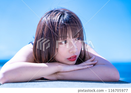 A young woman lying on a breakwater and enjoying the sea A young woman lying on a breakwater and enjoying the sea 116705977