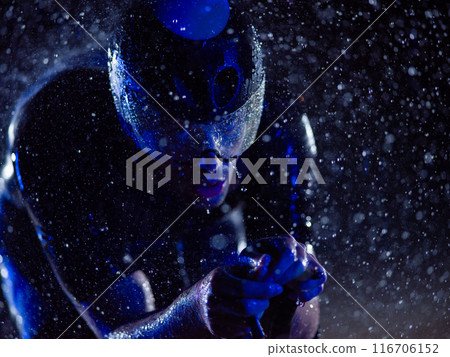 A triathlete braving the rain as he cycles through the night, preparing himself for the upcoming marathon. The blurred raindrops in the foreground and the dark, moody atmosphere in the background add A triathlete braving the rain as he cycles through the night, preparing himself for the upcoming marathon. The blurred raindrops in the foreground and the dark, moody atmosphere in the background add 116706152