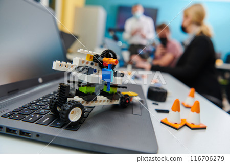A group of colleagues working together in a robotics laboratory, focusing on the intricate fields of robotics and 3D printing. Showcase their dedication to innovation, as they engage in research A group of colleagues working together in a robotics laboratory, focusing on the intricate fields of robotics and 3D printing. Showcase their dedication to innovation, as they engage in research 116706279