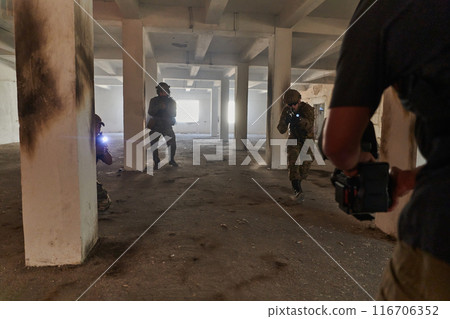 A professional cameraman captures the intense moments as a group of skilled soldiers embarks on a dangerous mission inside an abandoned building, their actions filled with suspense and bravery 116706352