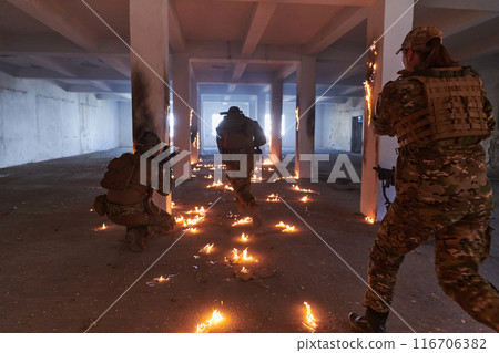 A group of professional soldiers bravely executes a dangerous rescue mission, surrounded by fire in a perilous building. A group of professional soldiers bravely executes a dangerous rescue mission, surrounded by fire in a perilous building. 116706382