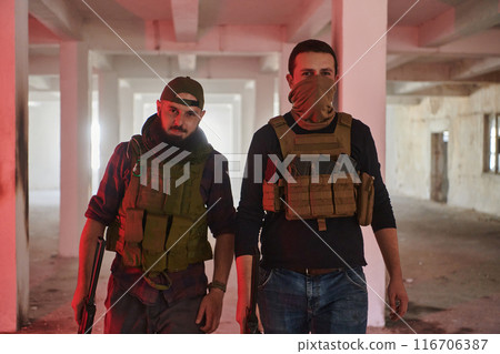 An abandoned building serves as the stronghold for a team of terrorists, fiercely guarding their occupied territory with guns and military equipment 116706387