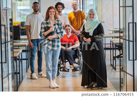 A diverse group of young business people congregates within a modern startup's glass-enclosed office, featuring inclusivity with a person in a wheelchair, an African American young man , and a hijab A diverse group of young business people congregates within a modern startup's glass-enclosed office, featuring inclusivity with a person in a wheelchair, an African American young man , and a hijab 116706455