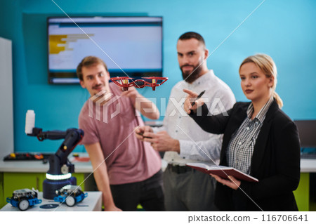 A group of students working together in a laboratory, dedicated to exploring the aerodynamic capabilities of a drone 116706641