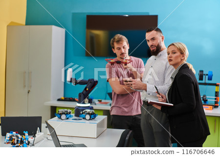 A group of students working together in a laboratory, dedicated to exploring the aerodynamic capabilities of a drone 116706646