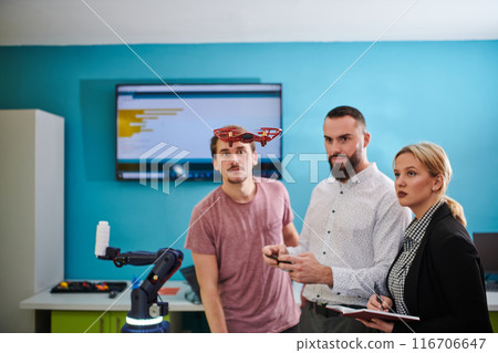 A group of students working together in a laboratory, dedicated to exploring the aerodynamic capabilities of a drone 116706647