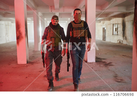 An abandoned building serves as the stronghold for a team of terrorists, fiercely guarding their occupied territory with guns and military equipment 116706698