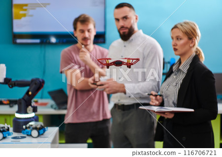 A group of students working together in a laboratory, dedicated to exploring the aerodynamic capabilities of a drone A group of students working together in a laboratory, dedicated to exploring the aerodynamic capabilities of a drone 116706721