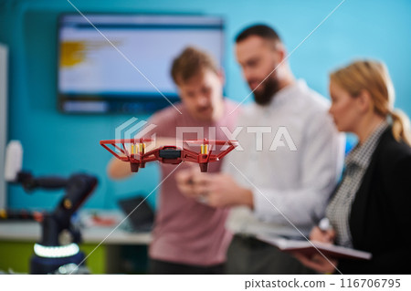A group of students working together in a laboratory, dedicated to exploring the aerodynamic capabilities of a drone 116706795